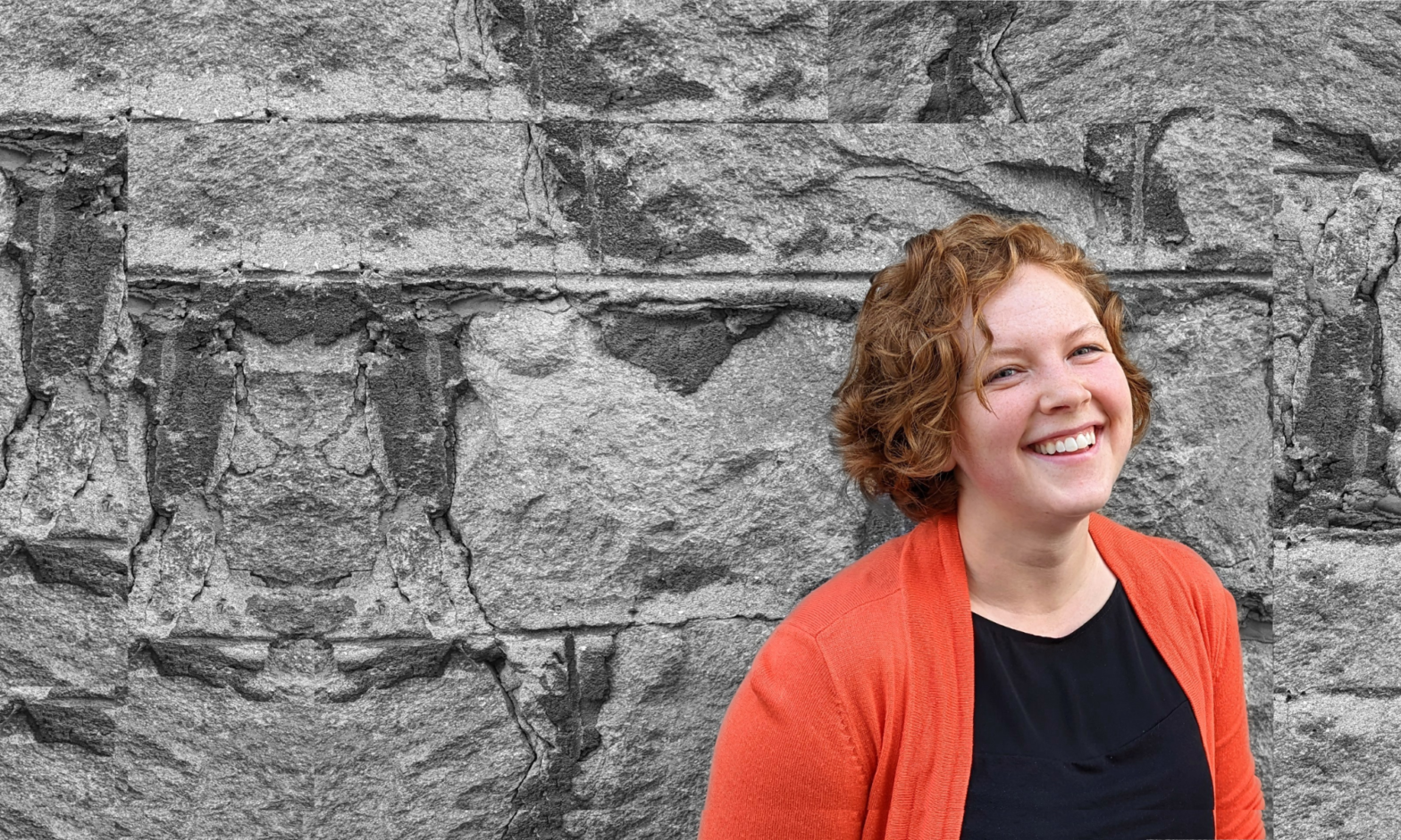 Nicola Schaan, occupational therapist has short curly red hair, freckles, and is smiling wearing an pinky orange cardigan in front of a brick wall
